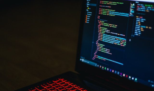 Computer screen with code and keyboard