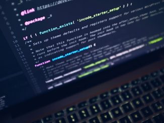Programming code on screen of black computer with keyboard