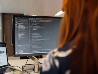 Software tester working on computer with screen