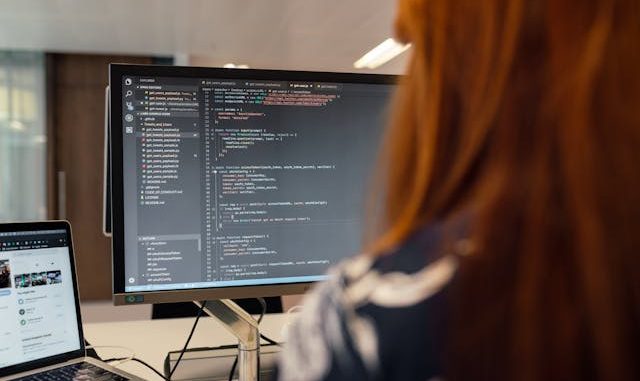 Software tester working on computer with screen