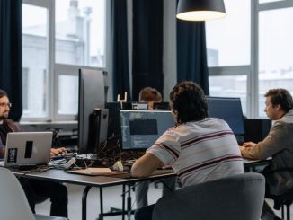 4 software developers and testers working on computer screens