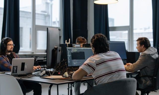4 software developers and testers working on computer screens