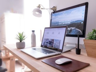 Two computers on office desk with ecommerce website screens